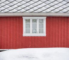 pared exterior de madera roja con ventana y techo foto