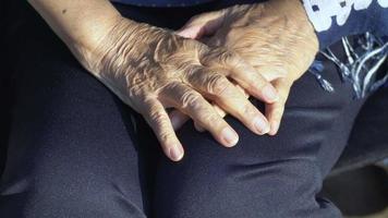 Elderly woman hand on wheelchair. video