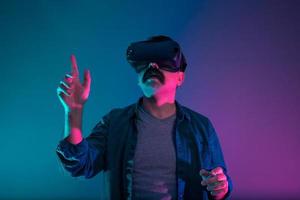 Turkish man is experiencing virtual reality, he is navigating and tapping the pages. photo