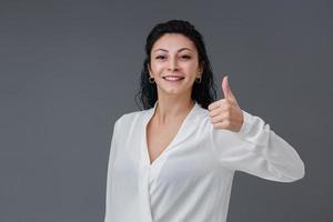 Beautiful smiling Turkish young woman, gestures concept, she thumbs up, includes copy space. photo