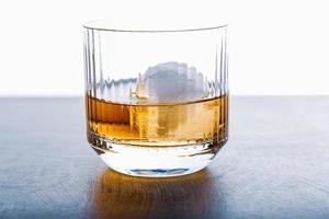 cubo de hielo en forma de esfera y vista de whisky de cerca desde el estudio. foto