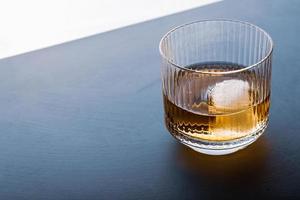 Sphere shaped ice cube and close up whiskey view from studio. photo