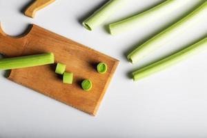 Minimal flat lay looking leeks view during slice progress over white, indludes copy space. photo