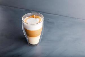 Perfectly gradient latte macchiato view over grey backdrop with copy space. photo