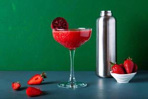 vista de detalle de primer plano de cóctel o jugo de fresa con elegante taza y frutas maduras. foto