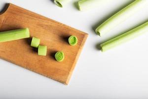 Minimal flat lay looking leeks view during slice progress over white, indludes copy space. photo