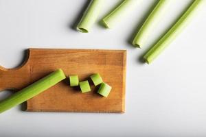 Minimal flat lay looking leeks view during slice progress over white, indludes copy space. photo