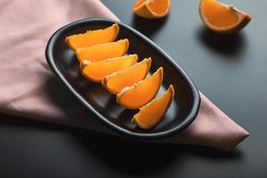 Sliced orange citrus view over black background, includes copy space. photo