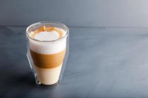 Perfectly gradient latte macchiato view over grey backdrop with copy space. photo