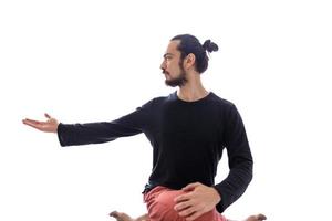 un joven blanco caucásico de pelo largo está realizando yoga en un estudio o casa. foto