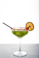 Close up single view of Green margarita with salt and sliced lemon from studio. Includes copy space. photo