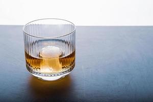 Sphere shaped ice cube and close up whiskey view from studio. photo