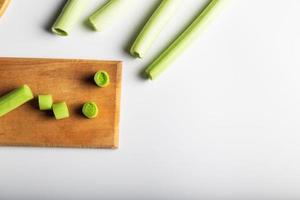 Minimal flat lay looking leeks view during slice progress over white, indludes copy space. photo