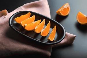 Sliced orange citrus view over black background, includes copy space. photo