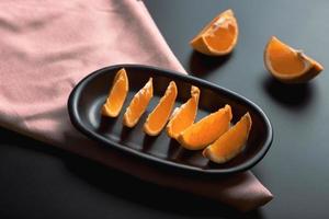 Sliced orange citrus view over black background, includes copy space. photo