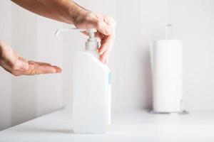 An anonymous hand is pushing down hand sanitiser, hygiene concept copy space includes. photo