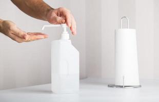 An anonymous hand is pushing down hand sanitiser, hygiene concept copy space includes. photo