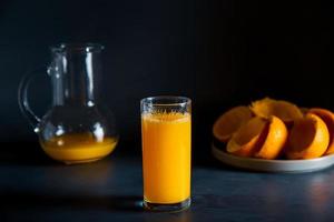 Dark moody orange juice squuze concept in studio. Includes copy space. photo