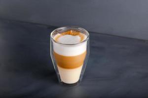 Perfectly gradient latte macchiato view over grey backdrop with copy space. photo