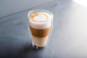 Perfectly gradient latte macchiato view over grey backdrop with copy space.