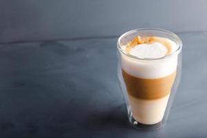 Perfectly gradient latte macchiato view over grey backdrop with copy space. photo