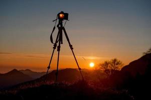 cámara en trípode para fotografiar la puesta de sol foto