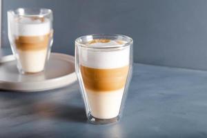 Perfectly gradient latte macchiato view over grey backdrop with copy space. photo