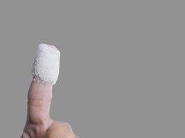 Pointing a wounded finger was treated with gauze attached To clean and prevent infection of the wound. Isolated image with gray background. Put clipping paths, copy space ready to use. photo