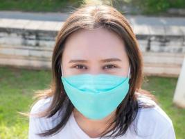 las mujeres asiáticas salen a relajarse felizmente afuera en el parque usando una máscara para prevenir infecciones de acuerdo con el nuevo estilo de vida normal para la seguridad de ellas mismas y de los demás. foto