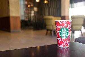 bangkok, tailandia - 24 de noviembre de 2021 - café de bebida caliente de Starbucks con tema navideño sobre la mesa. foto