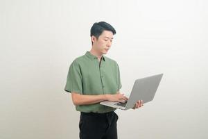 joven, asiático, usar la computadora portátil, en la mano foto