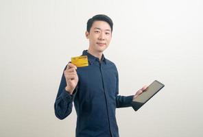 portrait young Asian man holding credit card and tablet photo