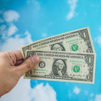 male hand with dollar isolated on sky background photo