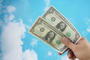 male hand with dollar isolated on sky background photo