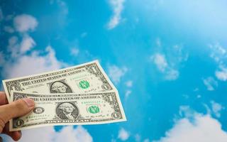 male hand with dollar isolated on sky background photo