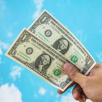 male hand with dollar isolated on sky background photo