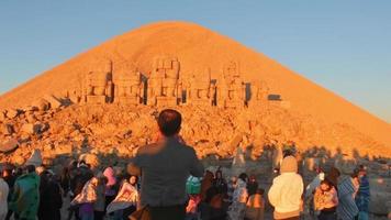monte nemrut, turquía, 2021 - multitudes de turistas haciendo turismo por un hito histórico en nemrut. concepto de viaje de pavo