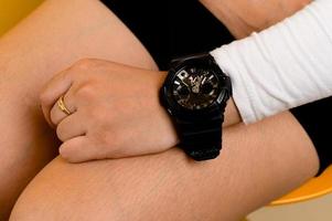 foto de primer plano de una mujer asiática una persona está mirando la hora en su reloj inteligente. mujer sentada