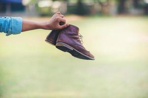 Hand and brown leather shoes photo