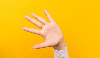 stop violence against women where there is no way to fight and those who are weaker Refrain from using a strong version Portrait of a young woman's hand on a yellow background photo