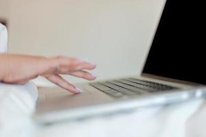 female hand working using laptop with black background for advertising Creative marketing and design Work on the mattress before going to bed and waking up. Design and designer business photo