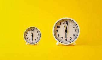 concept of time two white watches placed on a yellow background rotation of time photo