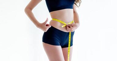 Close-up of a woman in a navy dress Slim figure measured around the waist and torso. Healthy nutrition and weight loss concept. photo