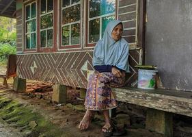 March 16, 2022 in Cianjur Regency, West Java, Indonesia.  An old grandmother was sitting on the veranda of her house. photo