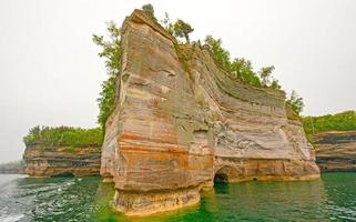 roca dentada en una colorida orilla del lago foto