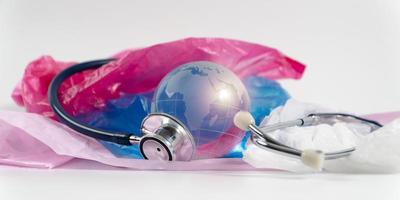Crystal globe and Stethoscope on plastic bag. Plastic waste overflows the world, The world is sick, Global Warming and Climate Change concept.