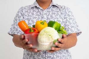 retrato de un hombre asiático sosteniendo un tazón lleno de verduras orgánicas frescas aisladas de fondo blanco, concepto de nutrición alimentaria saludable, concepto de nutrición alimentaria saludable, vegetariano foto