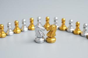 Gold and silver Chess Knight figure against pawn. Strategy, Conflict, management, business planning, tactic, politic, communication and leader concept photo