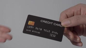 mão de homem dando cartão de crédito para mão de mulher. fundo isolado. video