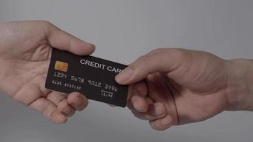 mano de hombre dando tarjeta de crédito a mano de mujer. fondo aislado. video